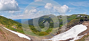 Summer mountain view with snow on mountainside (with observatory ruins on Chornogora Ridge, Ukraine