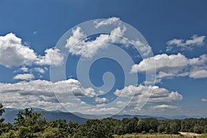 Summer mountains green grass and blue sky with clouds.