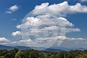 Summer mountains green grass and blue sky with clouds.