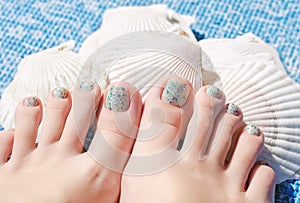 Summer multi color pedicure on female feet.