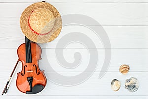 Summer music vacation background. Violin and staw hat on white background with space for your text