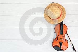 Summer music vacation background. Violin and staw hat on white background with space for your text