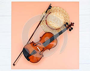 Summer music vacation background. Violin and straw hat on white background with space for your text