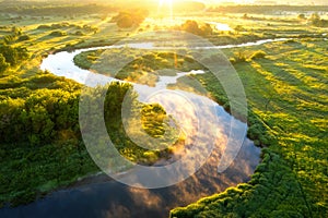 Summer nature background. Scenic sunny river at sunrise view from above. Beautiful bright nature landscape of riverside aerial