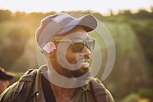 In summer in nature. Close-up young african man walking, strolling alone in forest, meadow, field. Amazing landscape