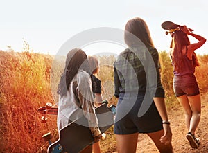 Summer, nature and friends walking with skateboard on path in countryside or exercise on holiday or vacation. Women