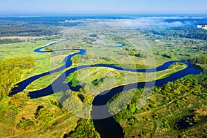 Summer nature landscape from above. River aerial view. Green meadow on riverside in the morning. Spring background