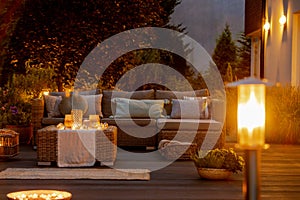 Summer night in the garden with trendy furniture, lights, lanterns and candles