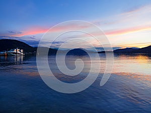 Summer night mountain landscape with boat on Lake Woerther, Carinthia, Austria.