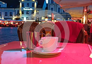 Summer night Street cafe  bokeh blurring city light evening restaurant table cup of coffee on top view candle lamp  light reflecti