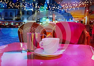 Summer night Street cafe  bokeh blurring city light evening restaurant table cup of coffee on top view candle lamp  light reflecti