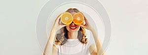 Summer, nutrition, diet and vegetarian concept. Happy healthy cheerful young woman covering her eyes with slices of orange fruits