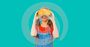 Summer, nutrition, diet and vegetarian concept. Happy healthy cheerful young woman covering her eyes with slices of orange fruits