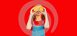 Summer, nutrition, diet and vegetarian concept. Happy healthy cheerful young woman covering her eyes with slices of orange fruits