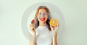 Summer, nutrition, diet and vegetarian concept. Happy healthy smiling young woman with slices of orange fruits on white background