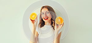 Summer, nutrition, diet and vegetarian concept. Happy healthy smiling young woman with slices of orange fruits on white background