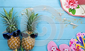 Summer objects of pineapple with sunglasses summer accessory on blue wooden background