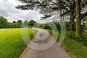 Summer in Omaha, Paved trail with a bench at a bend at Ed Zorinsky lake park, Omaha, Nebraska