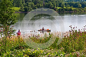 Summer in Omaha, Two boaters in kayaks with Shoreline and sky reflections in the lake at Ed Zorinsky Lake Park Omaha NE