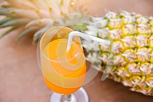 Summer orange and pineapple juice glass and fresh pineapple tropical fruits