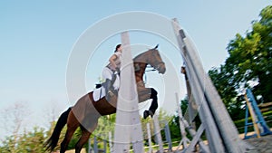 Summer, outdoors, girl rider, jockey riding on a thoroughbred beautiful brown stallion, horse, on the training ground