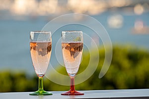 Summer party, drinking of French champagne rose sparkling wine in glasses with view on fishermen harbour of Toulon, France