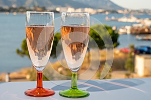 Summer party, drinking of French champagne rose sparkling wine in glasses with view on fishermen harbour of Toulon, France