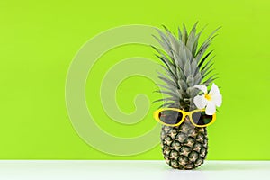 Summer in the party. Hipster Pineapple Fashion in sunglass bright beautiful color in holiday, Creative art fruit green background.