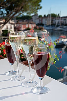 Summer party with kir royal cocktail, tasting of French brut champagne sparkling wine and cold creme cassis in glasses in yacht