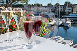 Summer party with kir royal cocktail, tasting of French brut champagne sparkling wine and cold creme cassis in glasses in yacht