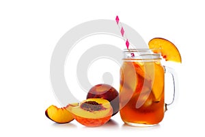 Summer peach iced tea in a mason jar glass with cut fruit isolated on white