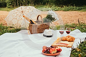 Summer Picnic on the beach at sunset in the white plaid, food and drink conception