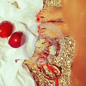 Summer picnic concept. Feet of standing woman in trendy dress near two red apples love symbol. Wedding accessories on white