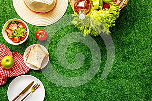 Summer picnic setting. Basket with food on red cloth, top view