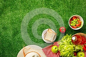 Summer picnic setting. Basket with food on red cloth, top view