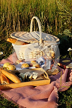 Summer picnic setting in the meadow in the rays of the sunset