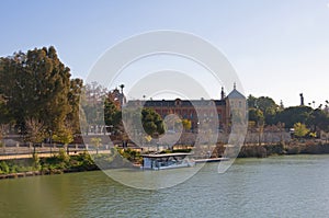 Summer pleasure boat on the river, San Telmo palace. Seville, Spain