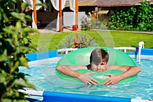 Summer pool with green circle and laughing guy sunbathing. Children in the swimming pool. Saturated blue water