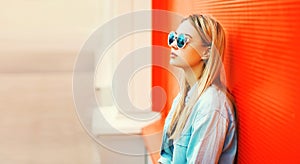 Summer portrait of beautiful blonde young woman wearing sunglasses, shirt in the city