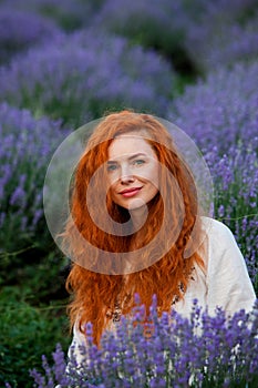 Summer portrait of a beautiful girl with long curly red hair