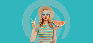 Summer portrait of beautiful young woman with fresh juicy slice of watermelon blowing her lips sends air kiss wearing straw hat on