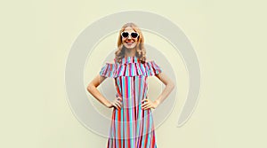 Summer portrait of beautiful young woman model wearing colorful dress and heart shaped sunglasses on white background