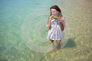 Summer portrait of fashion of the surprising healthy woman posing before the blue ocean on the tropical hot exotic island, ho