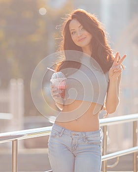 Summer portrait of a girl with a drink in the city