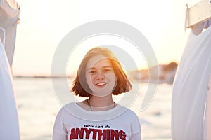 Summer portrait of girl smiling happily on beach, female has vacation, enjoying warm and sunshine on bank of river or lake.