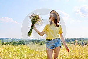 Summer portrait of happy 30s woman with bouquet of wildflowers