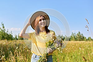 Summer portrait of happy 30s woman with bouquet of wildflowers