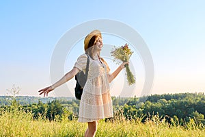 Summer portrait of happy 30s woman with bouquet of wildflowers