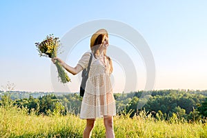 Summer portrait of happy 30s woman with bouquet of wildflowers