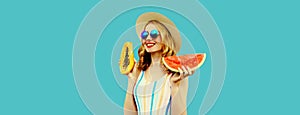 Summer portrait of happy smiling young woman with fresh juicy slice of watermelon and papaya wearing straw hat, sunglasses on blue